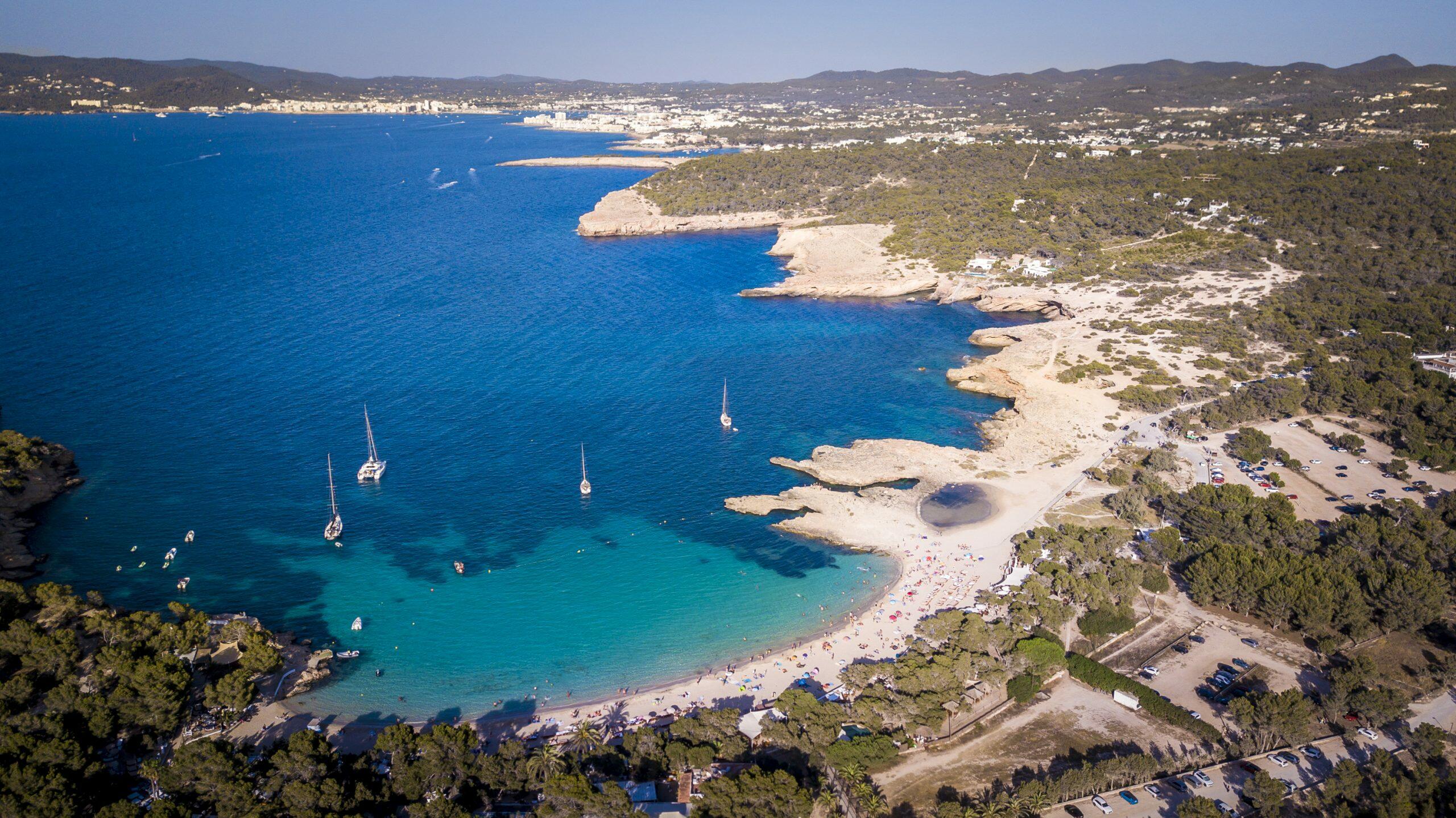 Vista aérea de Cala Bassa en Sant Josep de sa Talaia, Ibiza, con veleros y una playa de arena