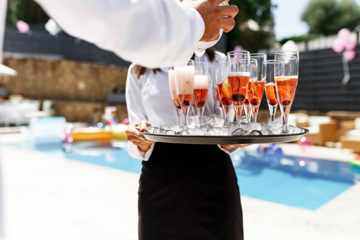 chef privado sirviendo champán junto a la piscina en villa de lujo en Ibiza