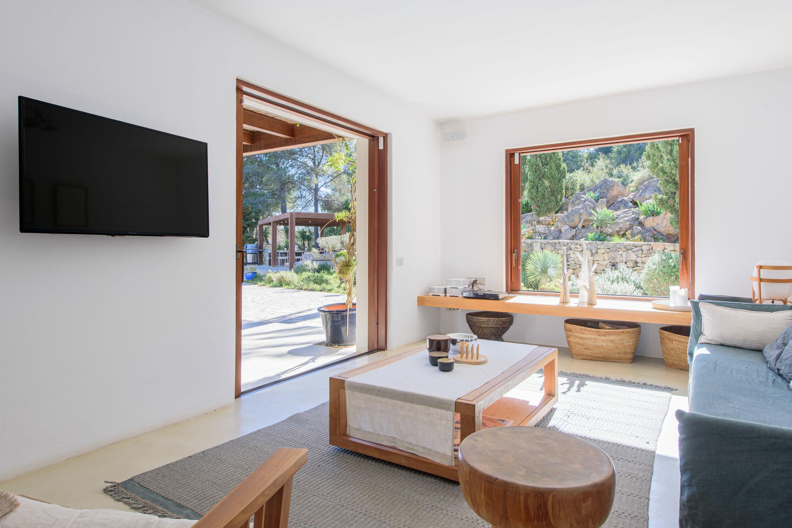 Luminoso salón en una vivienda de Ibiza con grandes aberturas al jardín y luz natural.