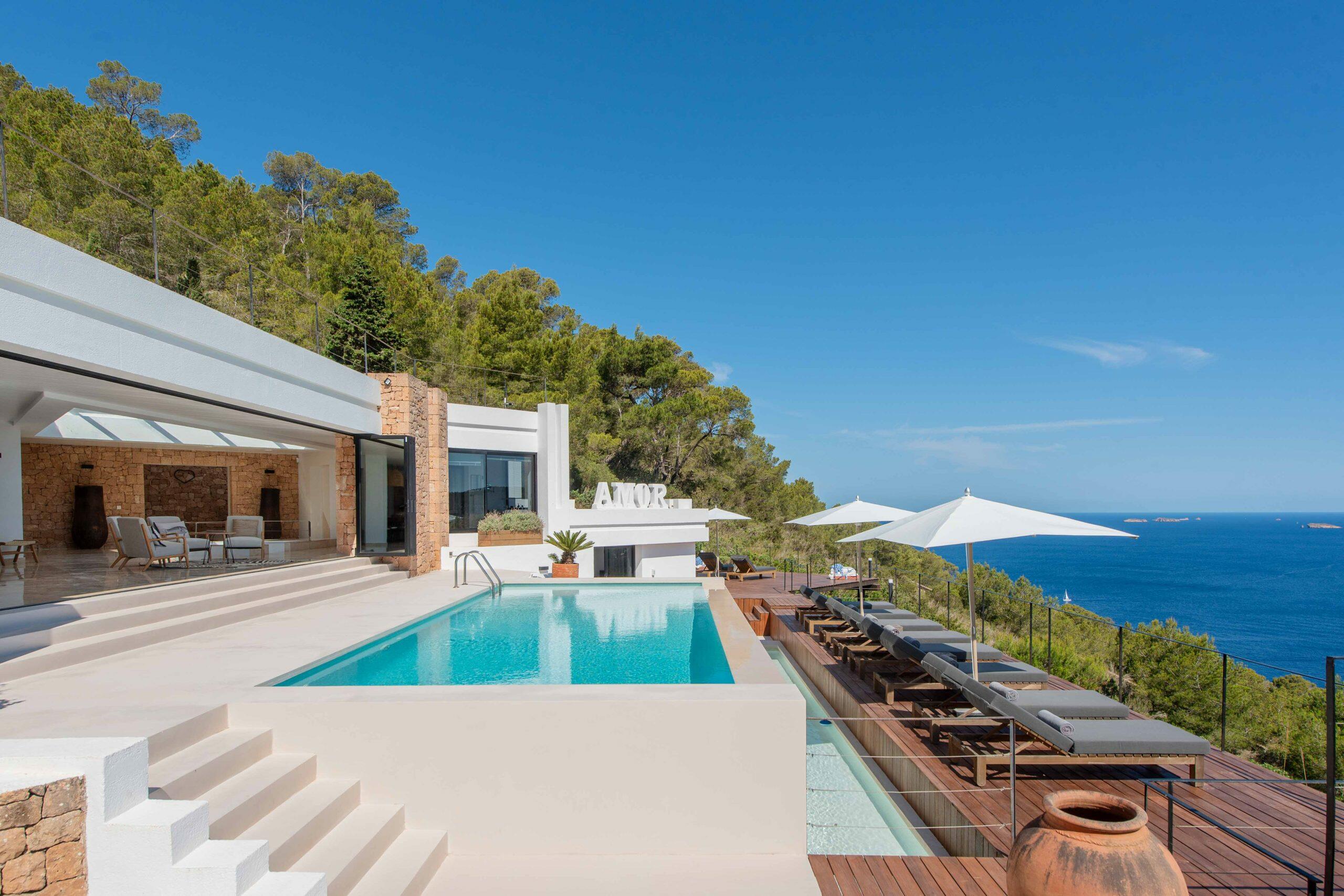 Villa en Ibiza con piscina, terraza solárium y vistas al mar Mediterráneo.